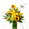 Yellow lilies and sunflowers in a clear glass vase