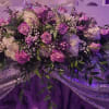 Lavender roses and cloudlike white hydrangeas form a low, wide centerpiece designed