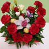 A bold heart-shaped ring of bright red carnations frames a creamy cluster