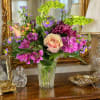 A peach-toned rose paired with magenta chrysanthemums and soft pink alstroemeria creates