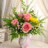 Soft pink roses take center stage in this romantic flower arrangement, designed