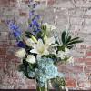Blue and white floral arrangement in a clear glass vase
