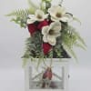 Crisp white magnolia-style silk blooms crown a classic white lantern in this