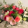 Mixed bouquet of roses, lilies, and alstroemeria in a glass vase