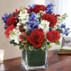 Our arrangement of red roses, white stock, and blue delphinium, expertly gathered