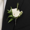 The Ivory Whisper Boutonniere is a sophisticated floral accessory designed for the