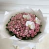 Large bouquet of pink roses with white orchids wrapped in white paper