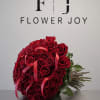 A stunning bouquet of 50 rich red roses, beautifully arranged with elegant