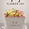 A cheerful arrangement of soft yellow and pink roses, accented with fresh