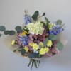 A charming bouquet of seasonal blooms in soft pastel shades, thoughtfully arranged
