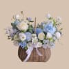 Soft blue and white blooms gathered in a woven wicker basket create