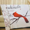 A soft quilted throw featuring a vivid red cardinal perched on a