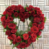 Heart-shaped wreath of red roses on a stand