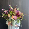 Weekly seasonal arrangement that showcases local flowers like smoke bush, geranium, and