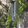 Hanging memorial wind chime with purple floral accents on a tree