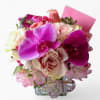 Pastel blossoms of that day roses orchids and more arranged in a