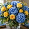 A cheerful and elegant floral arrangement featuring lush clusters of vibrant blue