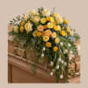 A generous casket spray crafted to convey warmth and gentle comfort, perfect