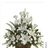 White lilies and carnations arranged in a wicker basket