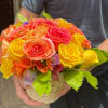 Basket of bright roses in yellow, orange, and pink