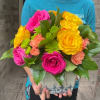 Bright mixed bouquet of pink and yellow roses in a decorative container