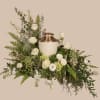 A low, expansive spray of white blooms arranged around a cream ceramic