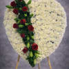A timeless heart-shaped standing tribute designed with soft white carnations and accented