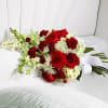 Red roses and white flowers arranged in a white chair