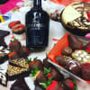 Assorted chocolate-covered strawberries and desserts around a Hennessy Black bottle
