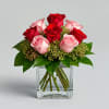 Red and pink roses arranged in a clear glass vase