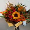 Bouquet of sunflowers and red roses wrapped in orange and gold paper
