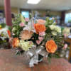 Bright orange roses take center stage in this rounded mixed bouquet, giving