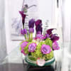 A lush and sophisticated floral arrangement where deep plum calla lilies rise