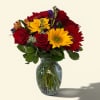 A bold cluster of red roses and sunny sunflowers greets the eye-this