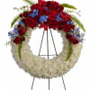 Red and white floral wreath on a black stand