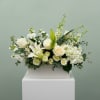 A beautiful arrangement of all white flowers to include lilies, hydrangea, stock