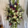 Tall floral spray with red and white roses, purple blooms, and green accents