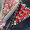 12 roses layer in pattern with baby breath and greenery wrapped in