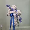 Vivid blue delphinium threads through a cloud of white roses, lilies, and