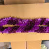 Purple flower lei on a cardboard surface
