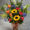 Colorful mixed bouquet in a glass vase with ribbon