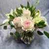 Pink roses and white lilies arranged in a clear glass vase