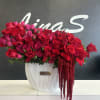 Large red and pink rose arrangement in a white vase