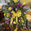 Sunlit yellow roses and lilies take center stage in this large mixed