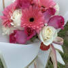 Pink gerbera daisies and roses wrapped in white paper