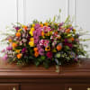 Large mixed floral spray on a wooden casket