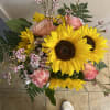 Bouquet of sunflowers, pink roses, and small pink filler flowers