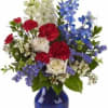 Mixed red, white, and blue flowers in a cobalt vase