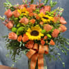 A lush, oversized arrangement featuring sunflowers, premium roses, spray roses, snapdragons, and