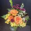 Three vibrant orange roses take center stage in this cheerful bouquet, surrounded